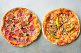 Fresh italian pizza with mushrooms, ham, tomatoes, cheese, olive, pepper on grey concrete background. Copy space. Top view.