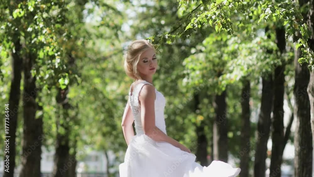 the bride dancing the park on her wedding day.The girl in a white dress with a train the bride dancing the park on her wedding day.The girl in a white dress with a train
