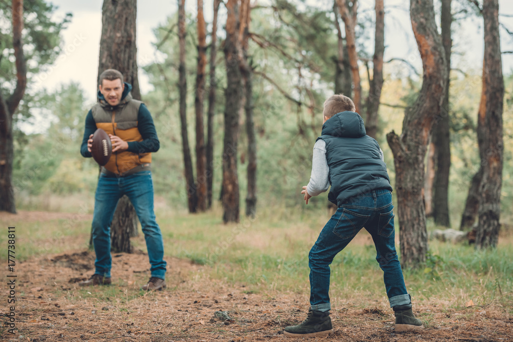 Fototapeta premium father and son playing with ball in forest