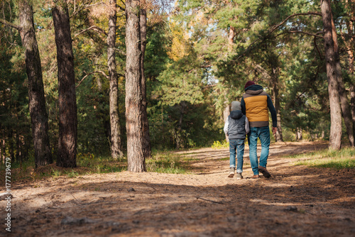 father and son walking in forest