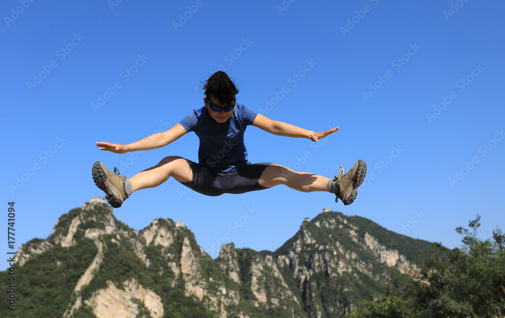 successful woman hiker jumping on mountain top successful woman hiker jumping on mountain top