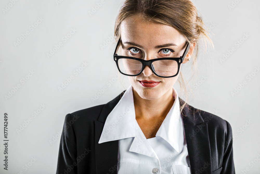 Young dark hair caucasian businesswoman wears glasses, in a white blouse and a black jacket in the white isolated background Young dark hair caucasian businesswoman wears glasses, in a white blouse and a black jacket in the white isolated background