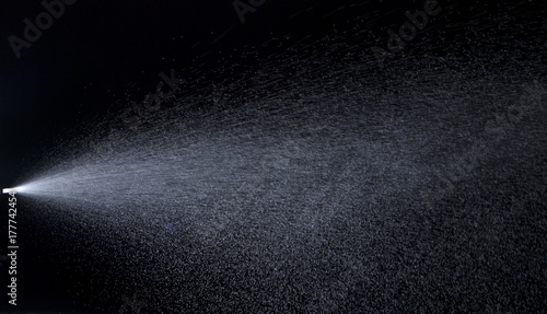 Water jet spraying on black background