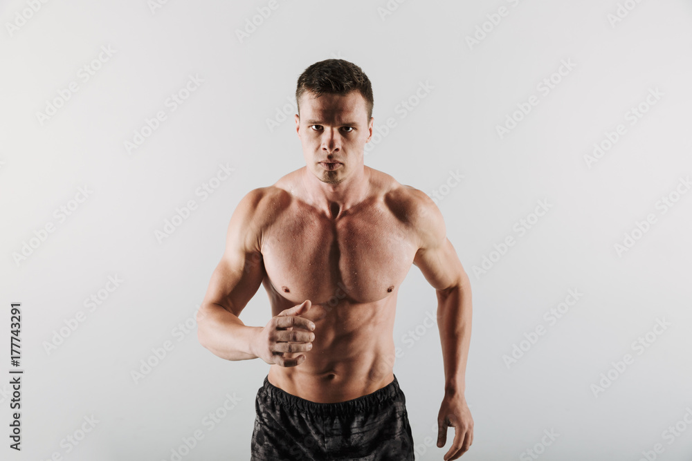 Strong young sportsman running isolated