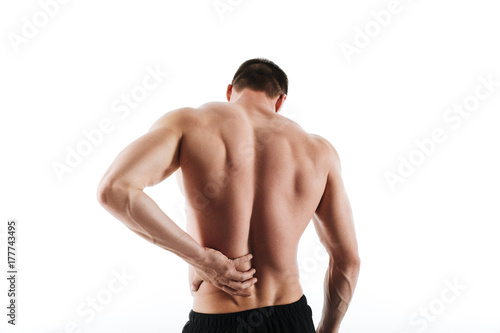 Back view of sportsman have a painful feelings in body.