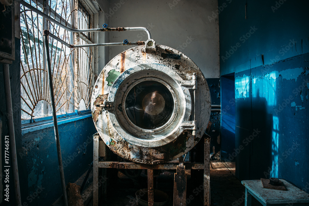 old vintage washing machine with shabby paint in an abandoned industrial building