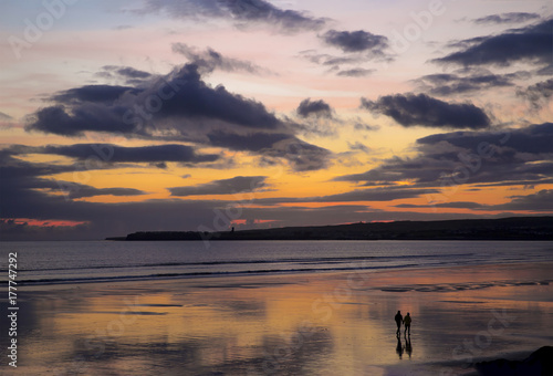 A Couple Walking on Lahinch Beach in the sunset