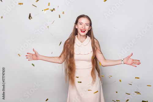 Happiness long haired blonde woman in pink dress, looking at camera and toothy smiling. photo