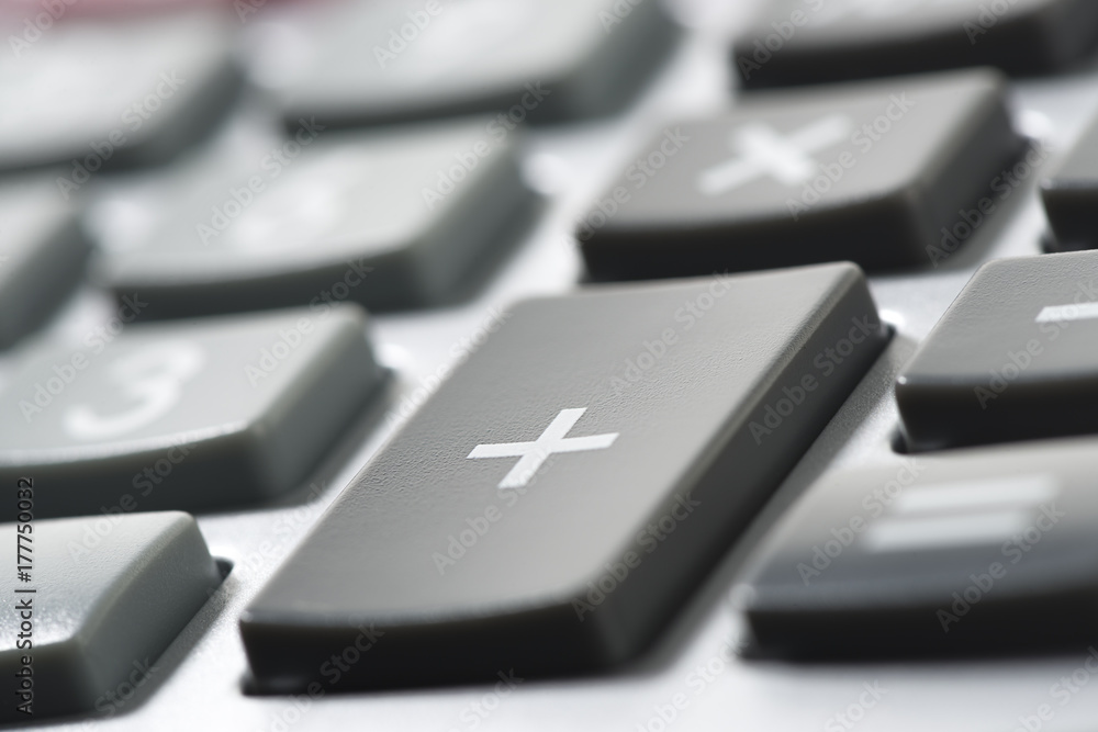 Close up of a calculator with plus sign at the foreground. Close up of a calculator with plus sign at the foreground.