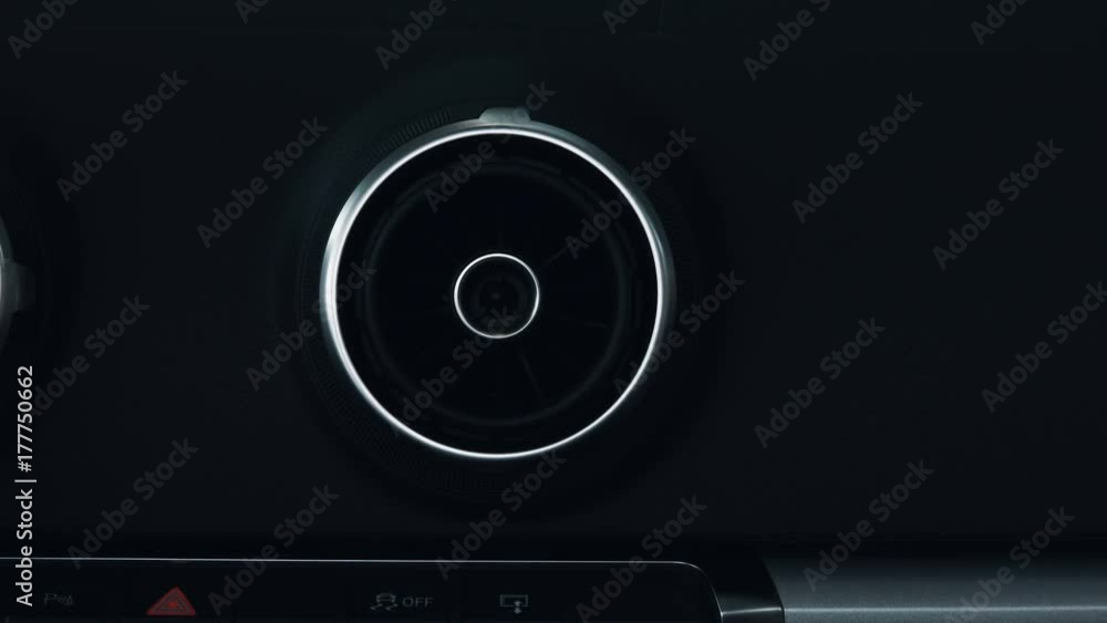 A car's air conditioning vent is moved in different directions. Extreme close up.