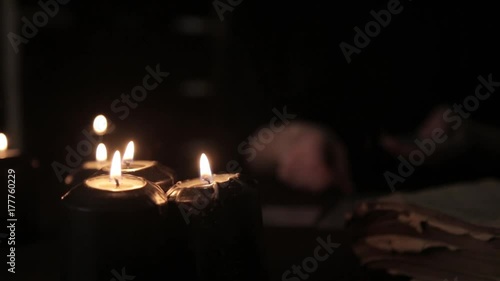 mystical beautiful woman in a black dress, divination on cards by candlelight