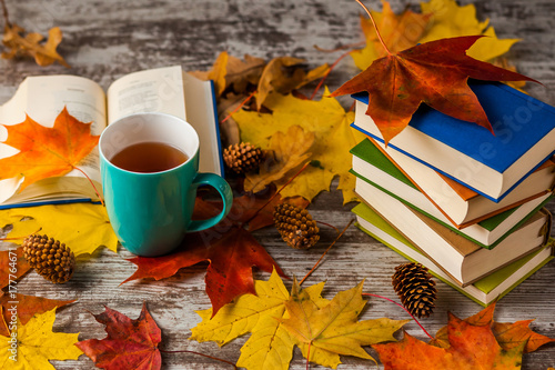 Autumn. An open book. Cup of tea, Coffee, cocoa. Yellow red leaves. Wooden background