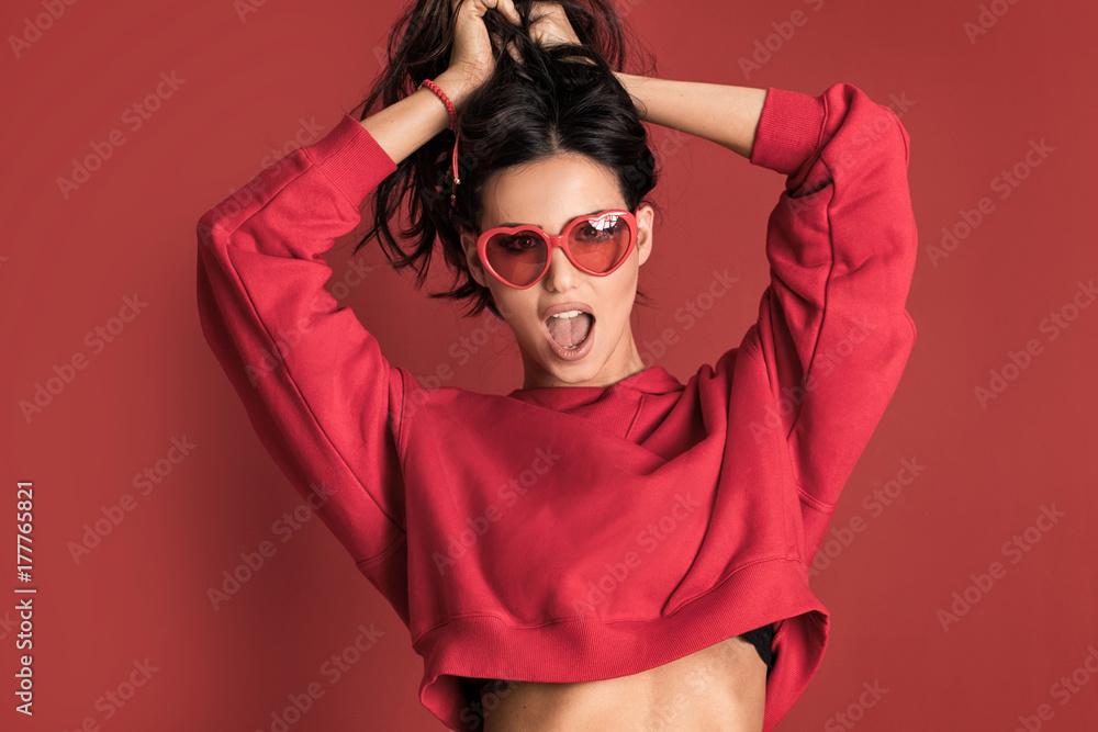 Fashionable beautiful woman posing on red background. Fashionable beautiful woman posing on red background.