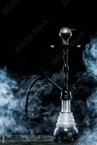 Hookah hot coals on bowl with black background. Stylish oriental shisha. Concept for bars and night clubs photo