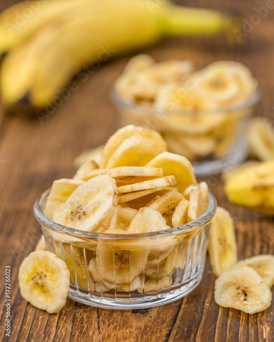 Dried Banana Chips on wooden background; selective focus
