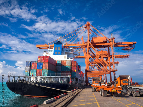 The container vessel  during discharging at an industrial port and move containers to container yard by trucks. photo