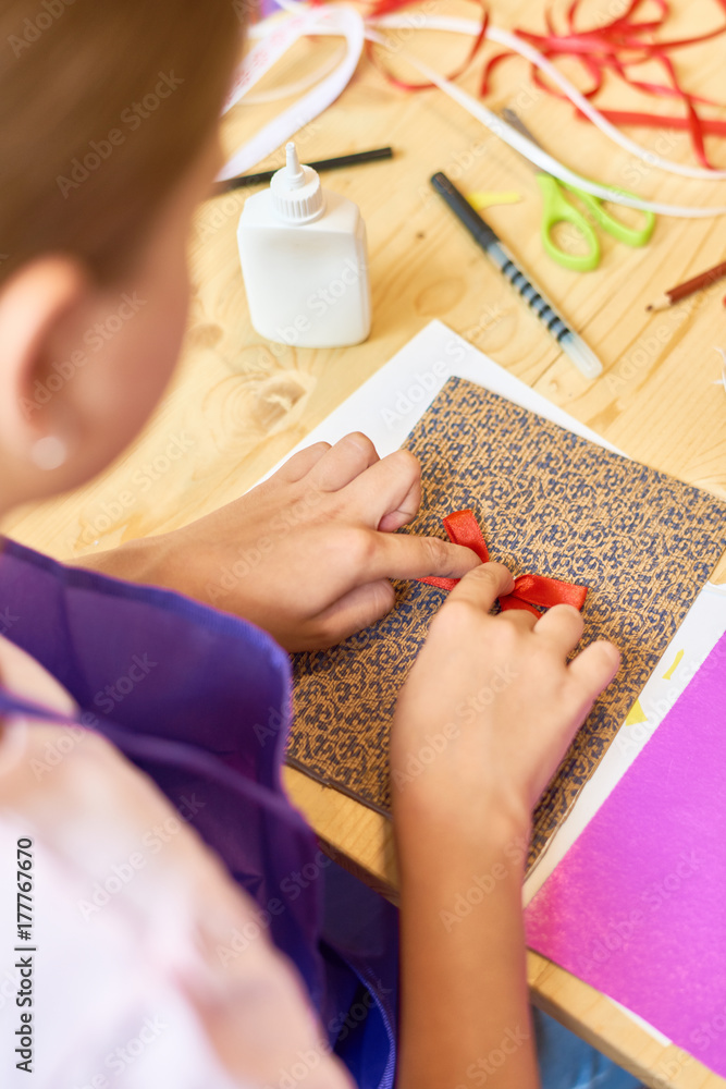 Φωτογραφία High angle portrait of teenage girl decorating beautiful handmade gift card duri