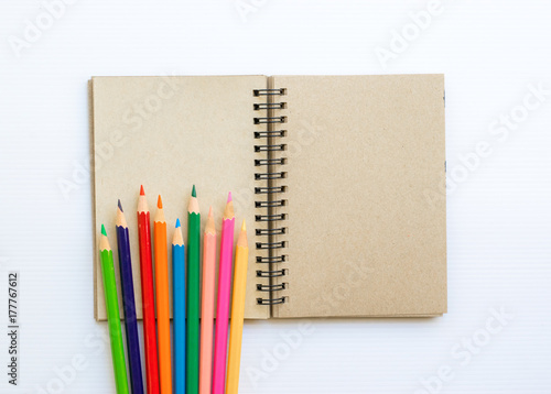 Notepad with pencil on wood board background.using wallpaper for education, business photo.Take note of the product for book with paper and concept, object or copy space.