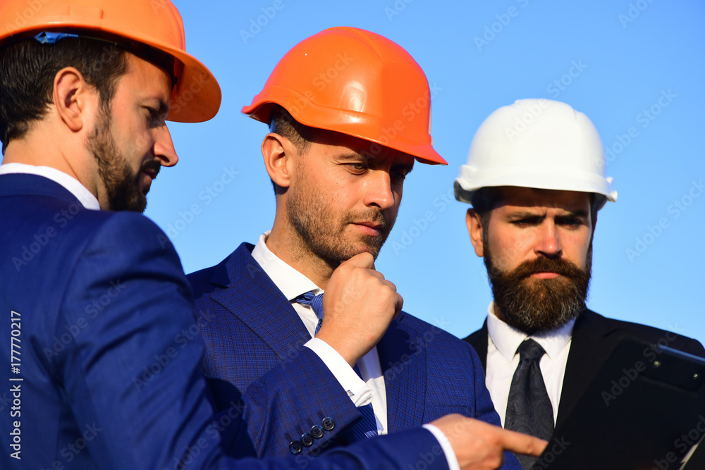 Workers and engineer hold meeting on project. Builders discuss plan Workers and engineer hold meeting on project. Builders discuss plan
