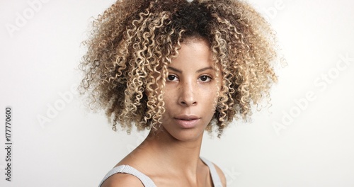 black woman with curly afro hiar and freckles portrait