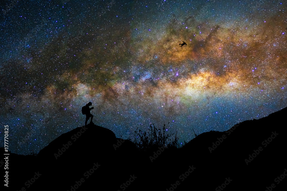 Silhouette of photographer with drone over the milky way on the dark sky background, photographer and transportation with astrophotography concept