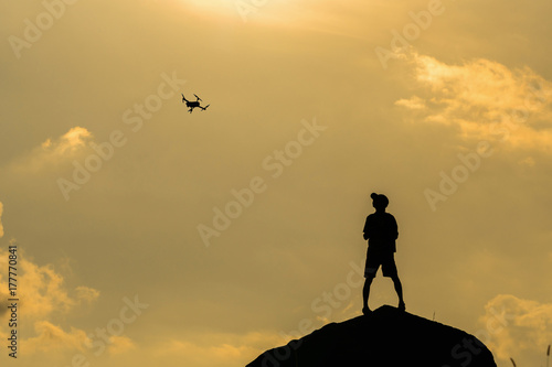 Silhouette of photographer with drone over the mountain, tphotographer and ransportation concept photo