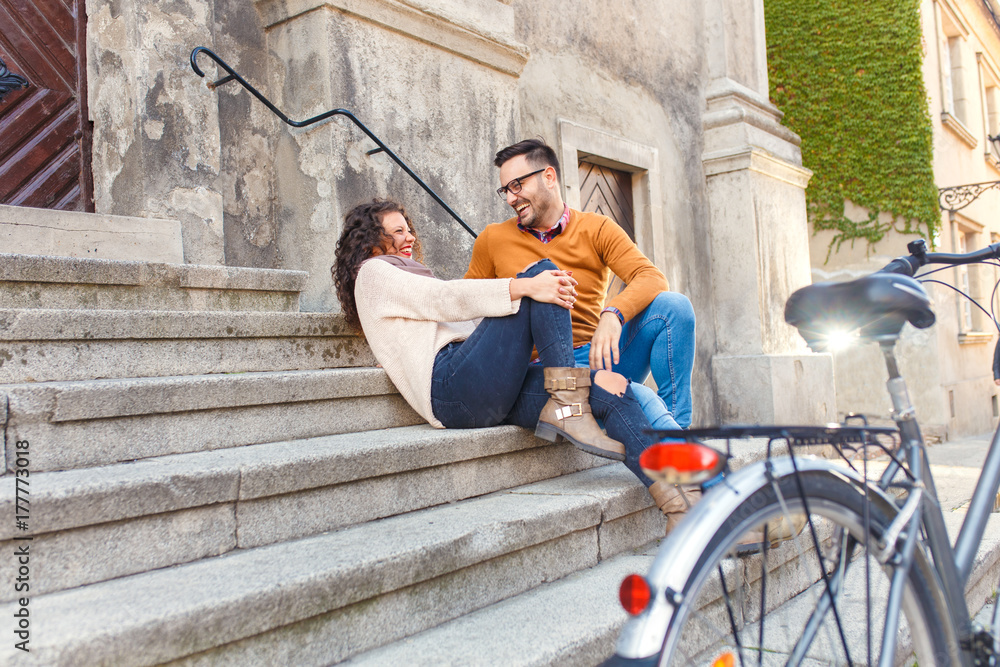 Young couple with bicycle siting on stairs in the city. Young couple with bicycle siting on stairs in the city.