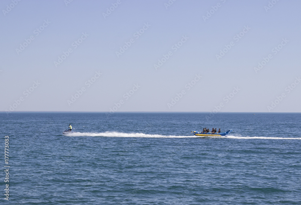 people riding on jet skis in the sea on a sunny day and clear skies