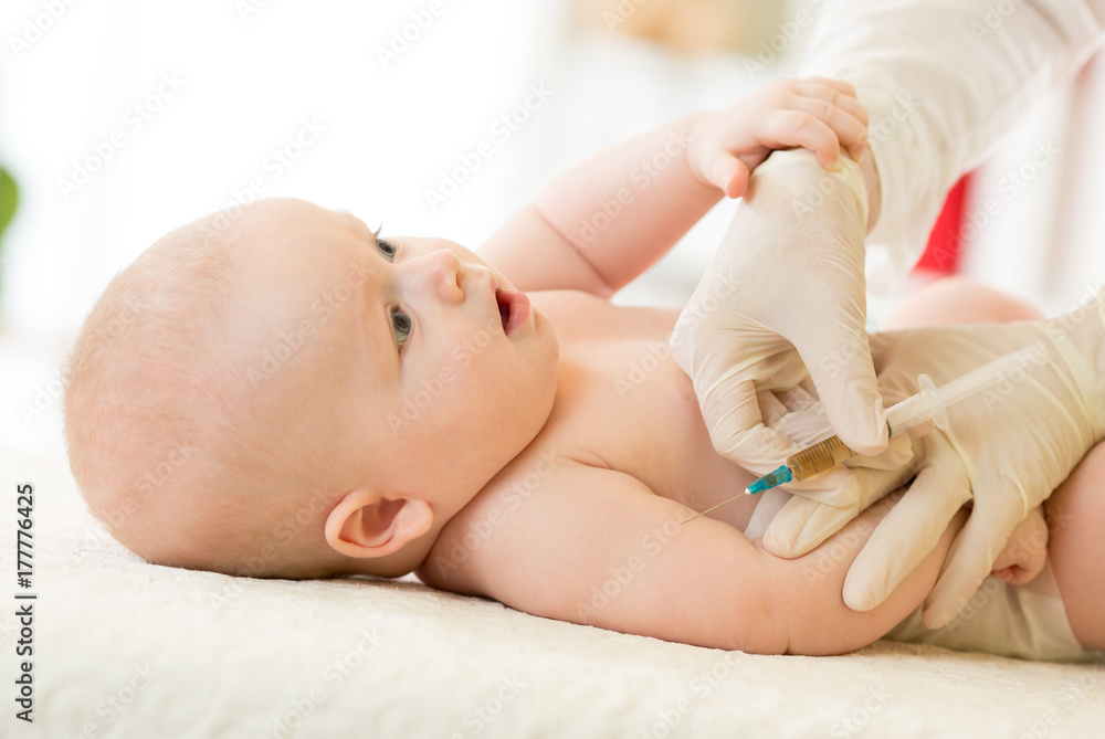 Close-up shot of pediatrician giving baby intramuscular injection in arm Close-up shot of pediatrician giving baby intramuscular injection in arm