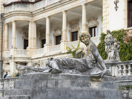 Statue of a girl on a pedestal in the garden of the Peles castle in Sinaia, in Romania