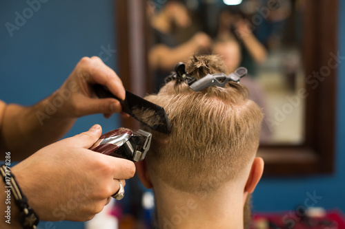 Man getting styling haircut by hairstylist at barbershop