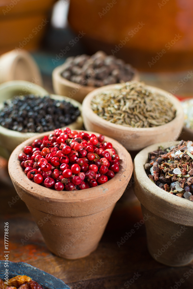 Variety of different spices with focus on pink Peruvian pepper, false pepper used in four peppers blends Variety of different spices with focus on pink Peruvian pepper, false pepper used in four peppers blends