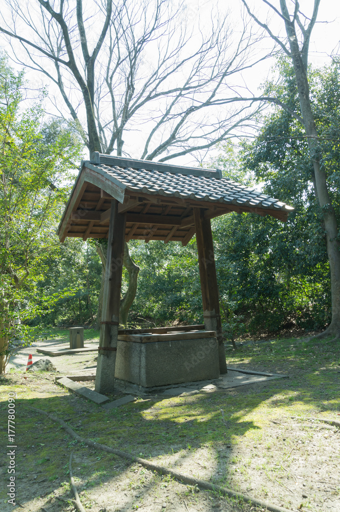 Beautiful old wooden well and outdoor scene on a sunny spring day Beautiful old wooden well and outdoor scene on a sunny spring day