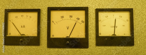 Three old analog instruments - Power factor meter, voltmeter and ampere meter isolated on grey background photo