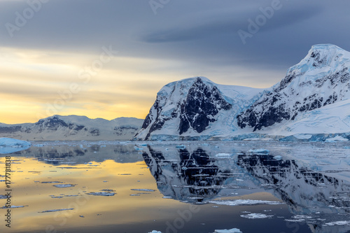 Cold still water of antarctic lagoon with glaciers and mountains in the background, Antarctica photo