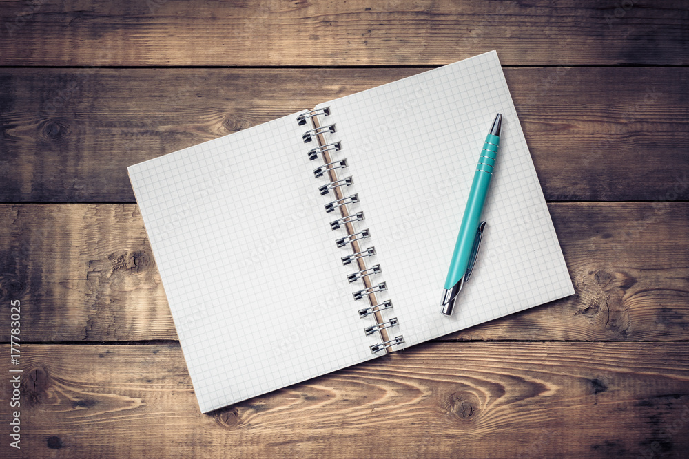 Blank paper notebook on brown wooden table background. Top view with copy space. Blank paper notebook on brown wooden table background. Top view with copy space.