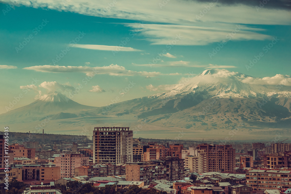 Impressive mount Ararat background. Yerevan cityscape. Travel to Armenia. Tourism industry. Cloudy sky. Armenian architecture. City tour. Urban landscape. Sightseeing concept. Copy space. Multistory