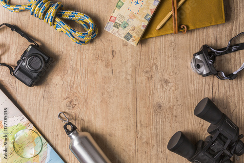 Overhead view of travel equipment for an adventure trip on wooden floor with copy space. Adventure travel concept.