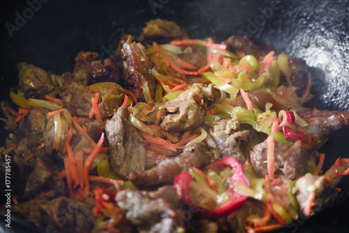 Preparation of meat with pepper, onions, carrots in a deep frying pan, sauté pan. Beef meat, delicious horse meat © alexxndr