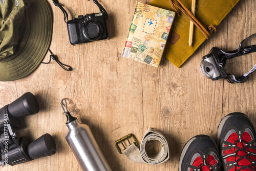 Overhead view of travel equipment for an adventure trip on wooden floor with copy space. Adventure travel concept.