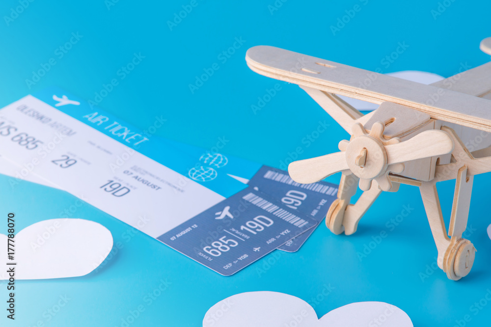 Wooden toy airplane and tickets on a background of blue sky with paper ...
