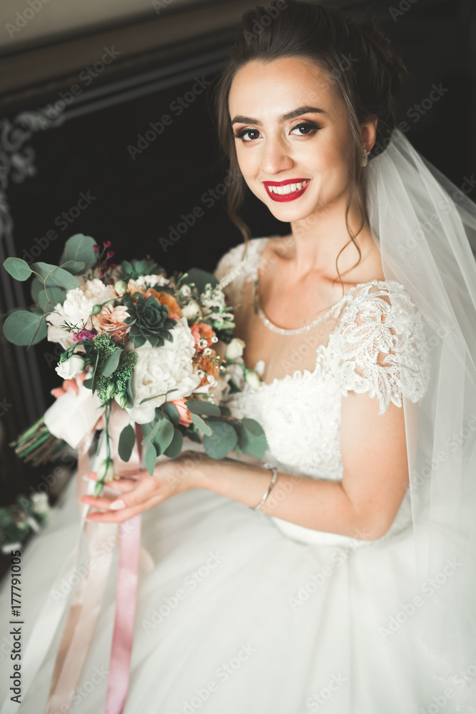 Naklejka premium Luxury bride in white dress posing while preparing for the wedding ceremony