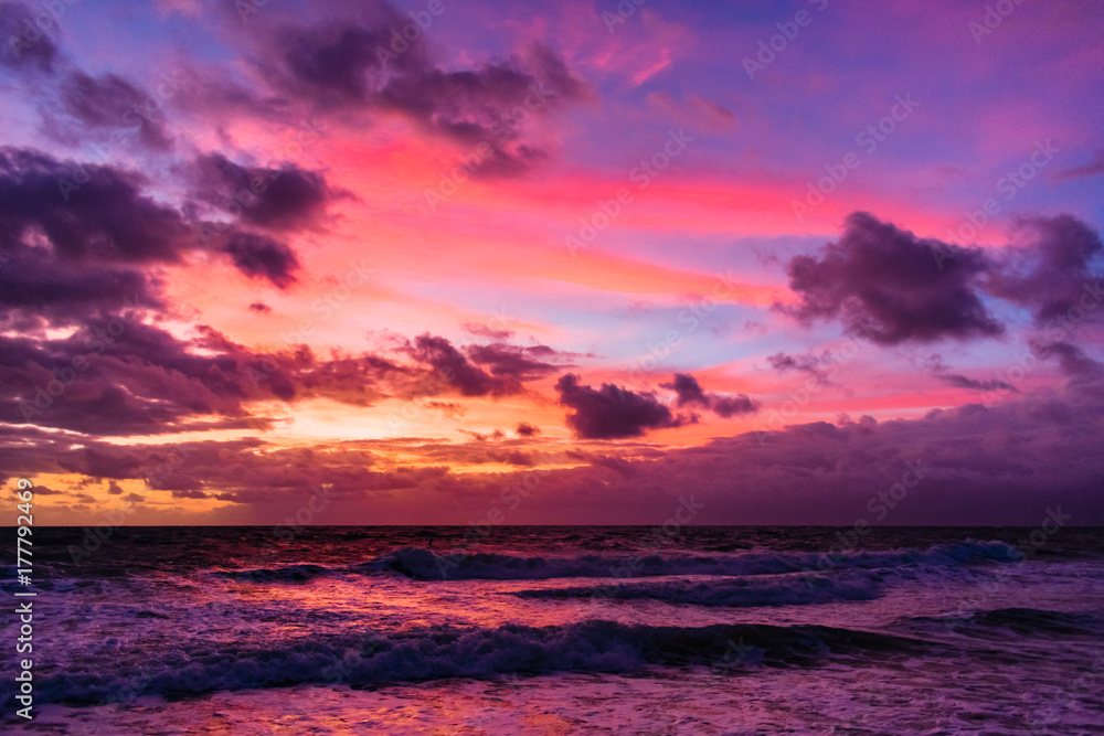 colorful sky as the sun rises and reflects on the wavey ocean
