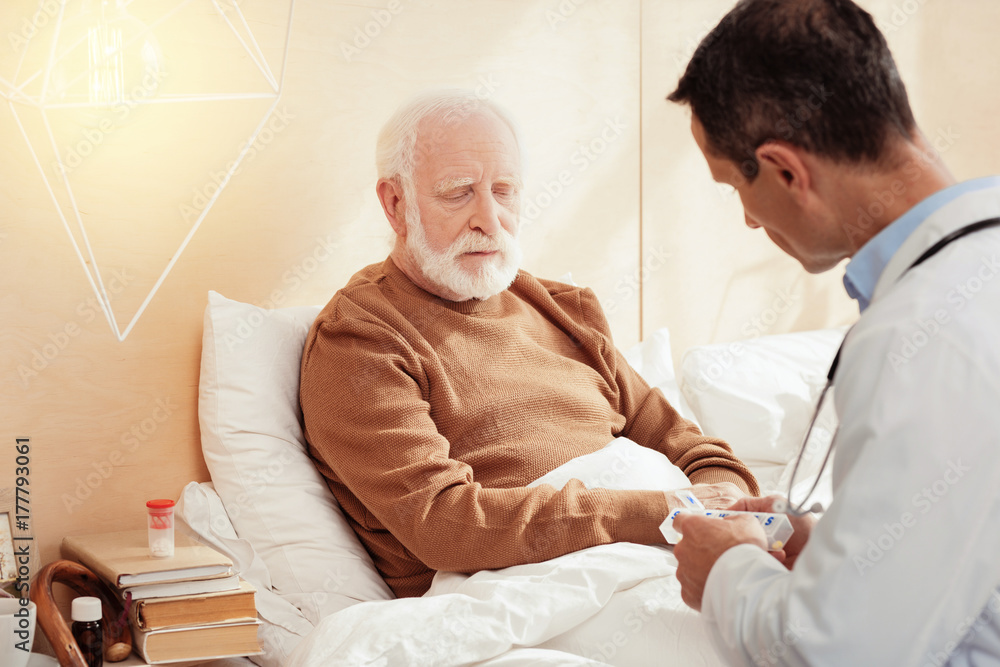 Fototapeta premium Sad grey-haired male person listening to his doc
