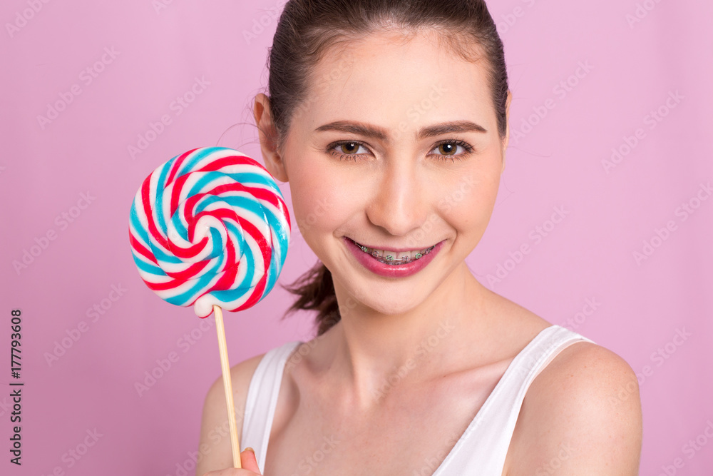 Portrait of happyBeautiful Woman holding lollypop with smiling. isolated on pink background