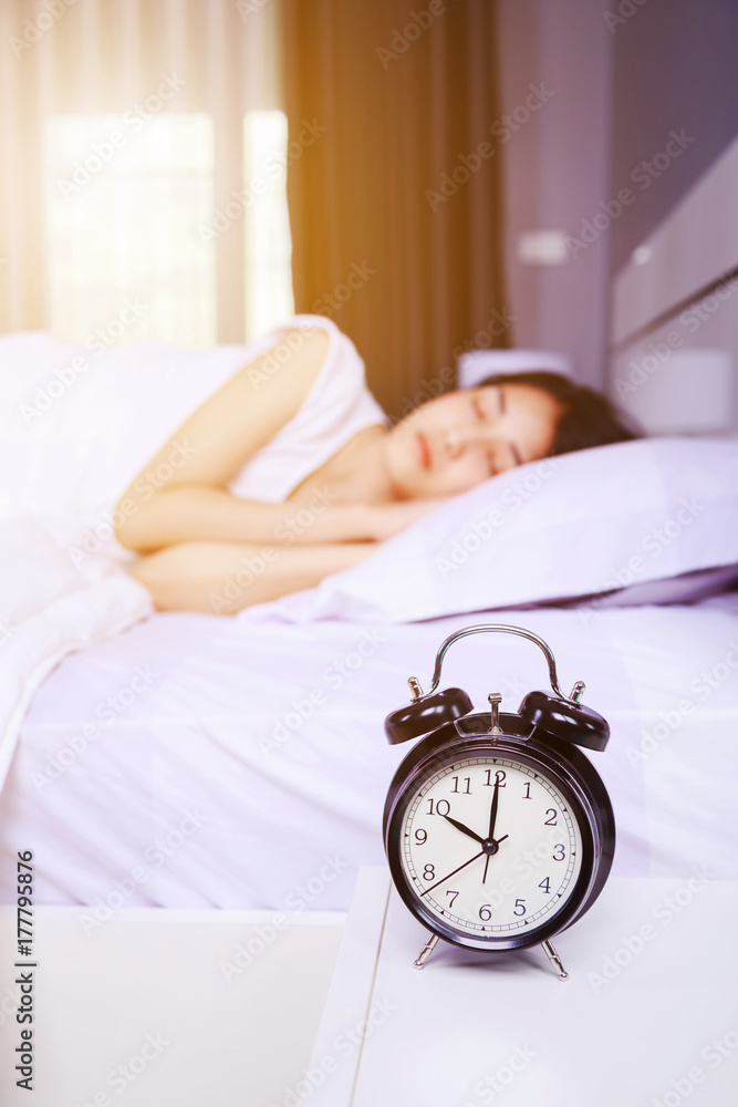 alarm clock on table and woman sleeping on bed in bedroom alarm clock on table and woman sleeping on bed in bedroom