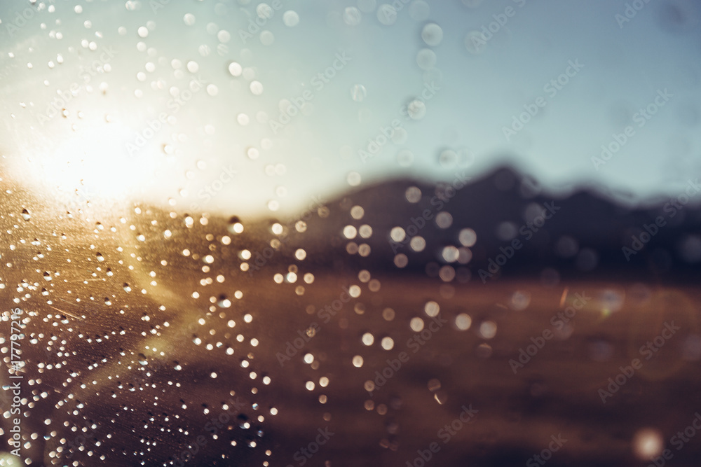 Raindrops On Car's Wind Shield On The Mountains And Sun, Selective Focus. Travel Journey Concept