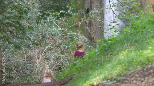 Mother and Daughter hiking in a forest countrypath and Waterfall photo