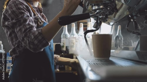 Female barista making fresh coffee on machine 
