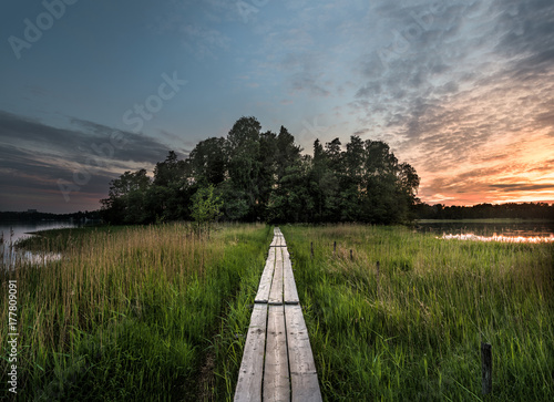 Duckboard path to the sunset. Beautiful nordic sunset landscape from Finland